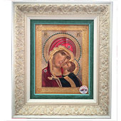 Gilded icon of baby Jesus and Holy Mary with decorative white frame
